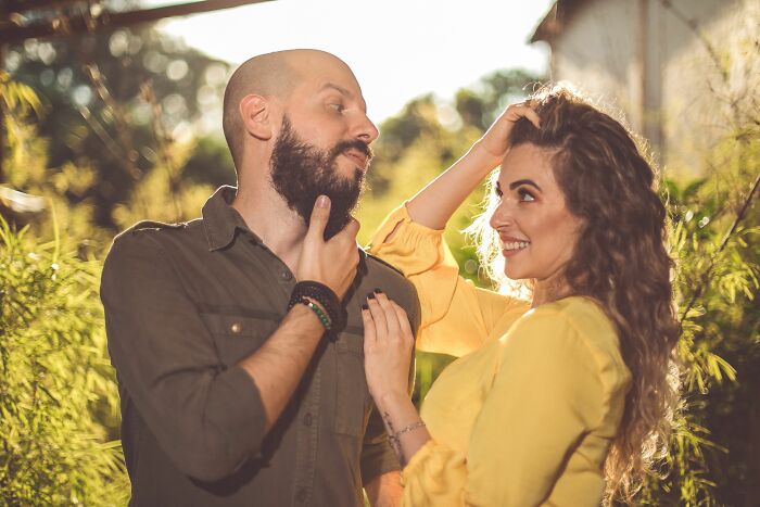 A couple posing outdoors, with the man's expression suggesting potential turn offs from his partner.