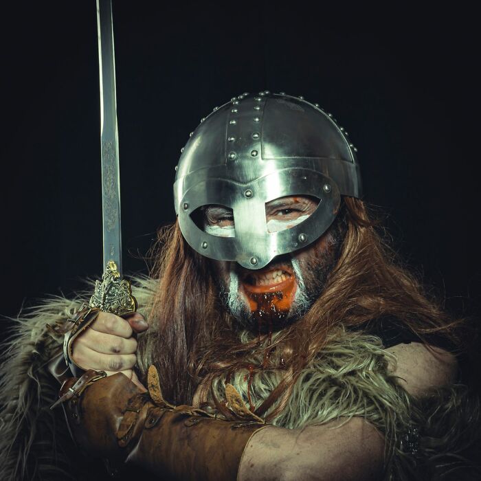 A man dressed as a Viking with a sword, helmet, and red-stained beard, illustrating the crazy facts.