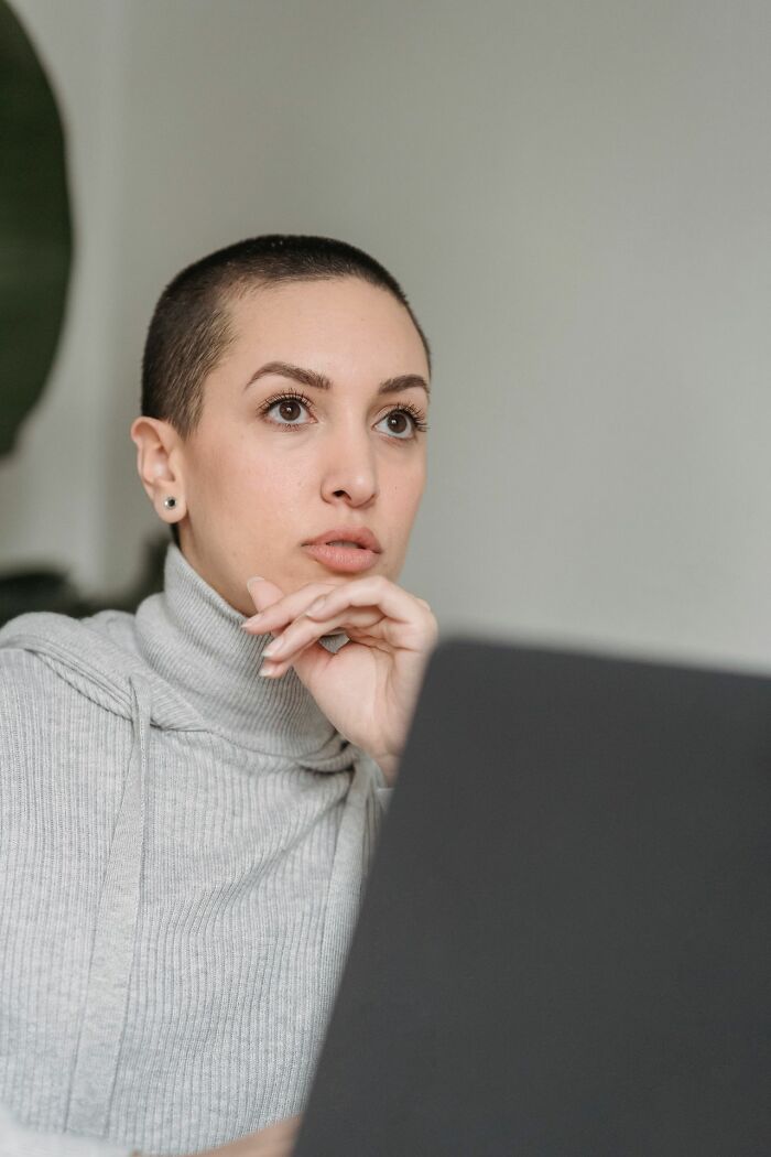 A woman with short hair and a contemplative expression, showing hints of being a secretly very smart person.