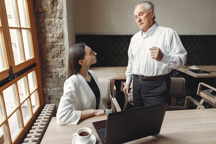 A woman and a man in an awkward situation, looking at each other in a cafe.