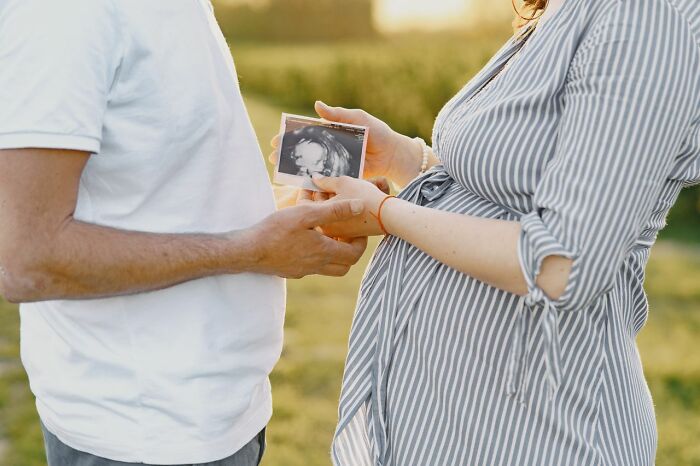 A couple holding an ultrasound image, potentially one of the worst things people found on partners phone.