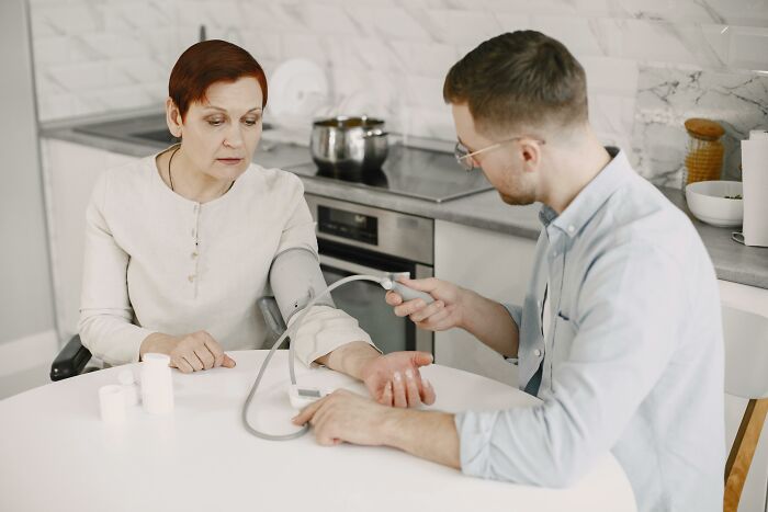 Man checking woman's blood pressure in a home setting health moment