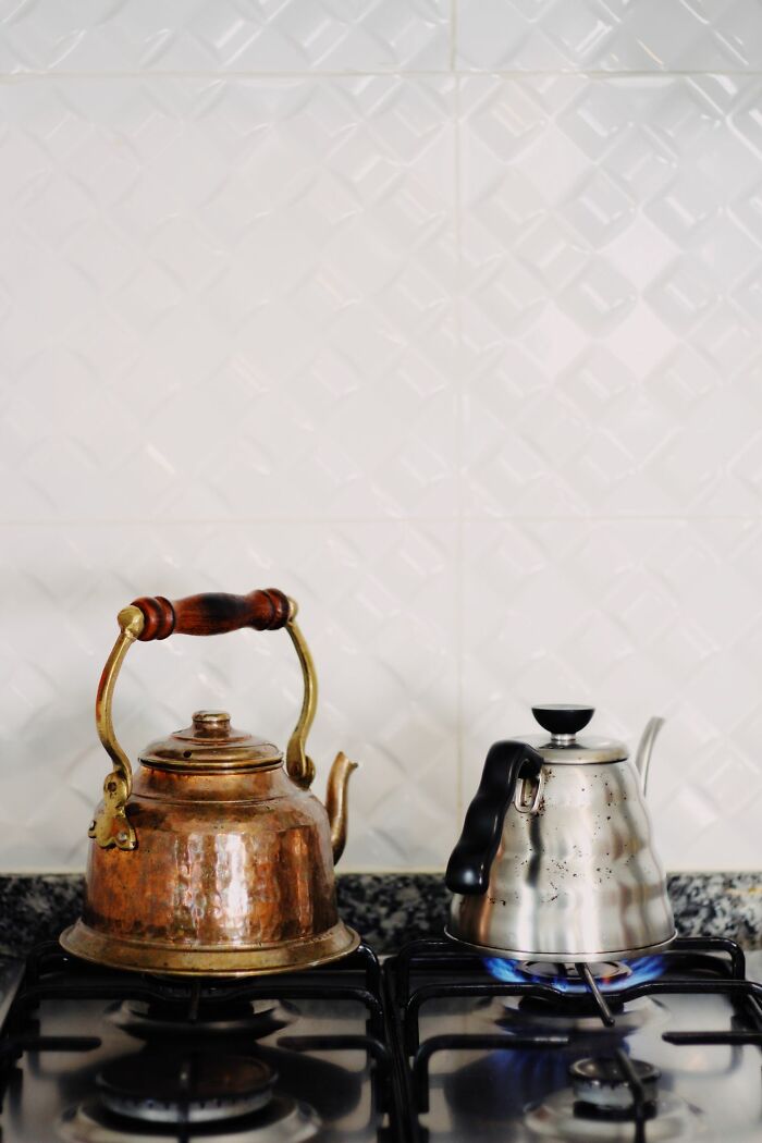Two kettles on a gas stove, one copper and one silver, showcasing facts and how crazy they sound.