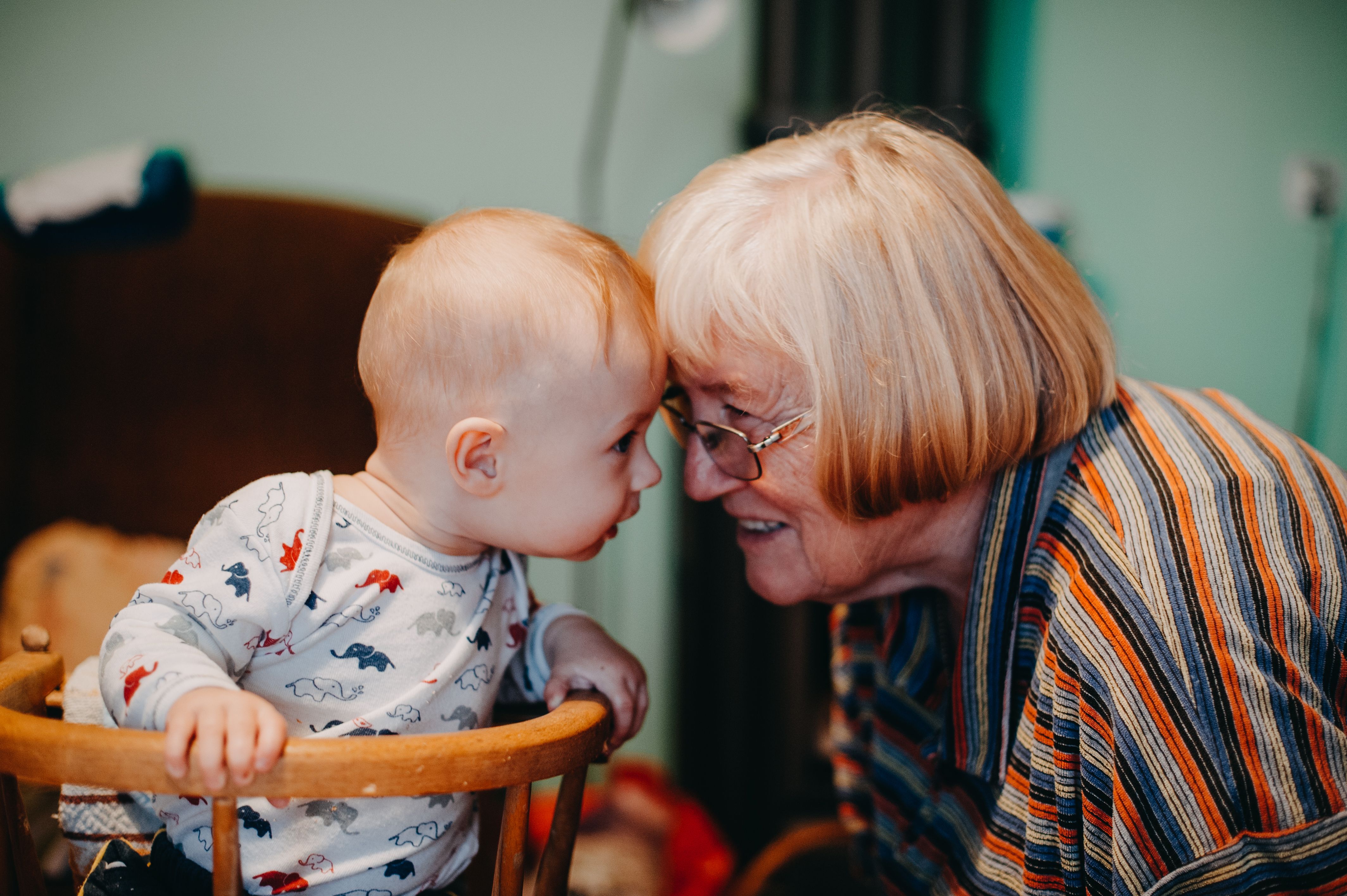 Grandmother and baby touching foreheads while babysitting and bonding