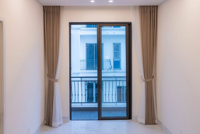 A sliding glass door with beige curtains opening to a balcony, hinting at a potentially unserious ER visit situation.