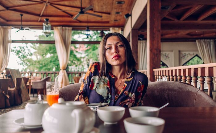 Woman with sad expression sitting alone at a restaurant table