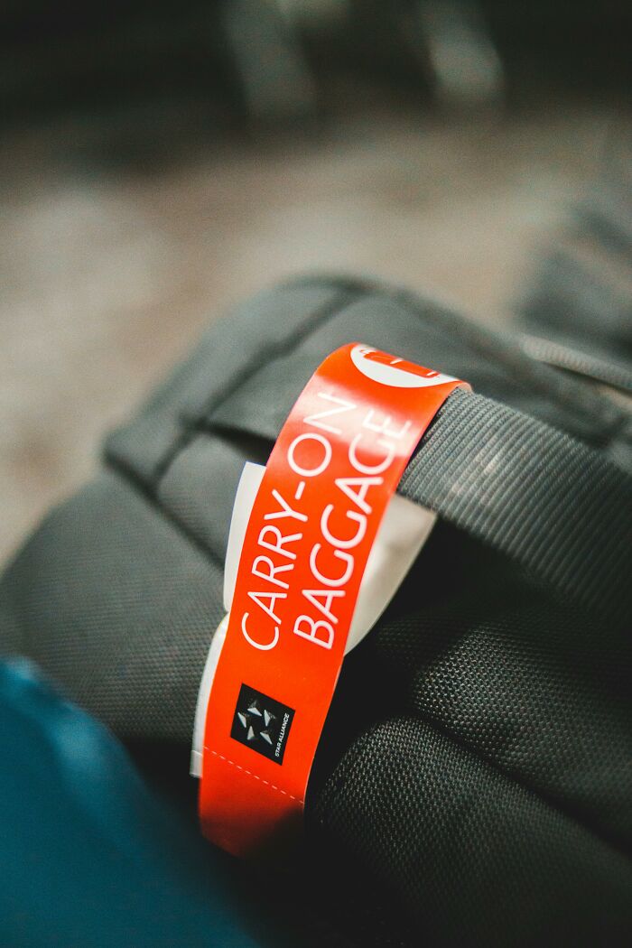 Close-up of a carry-on baggage tag attached to black luggage