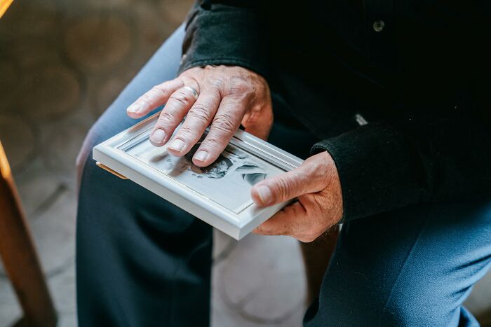 Man holding framed photo reflecting on moments men realized lives would never be the same