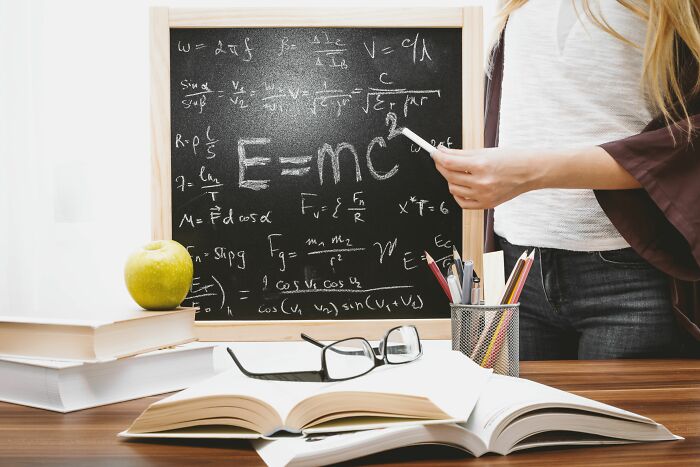 A hand points to the equation E=mc^2 on a blackboard, highlighting a moment of clarity or a breaking point where people snapped.