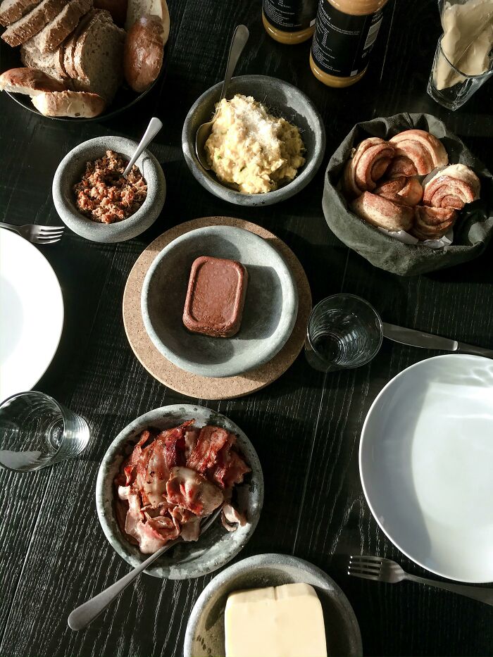 Traditional British breakfast with bacon, bread, and spreads on table
