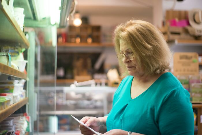 Woman reading a grocery list inside a store