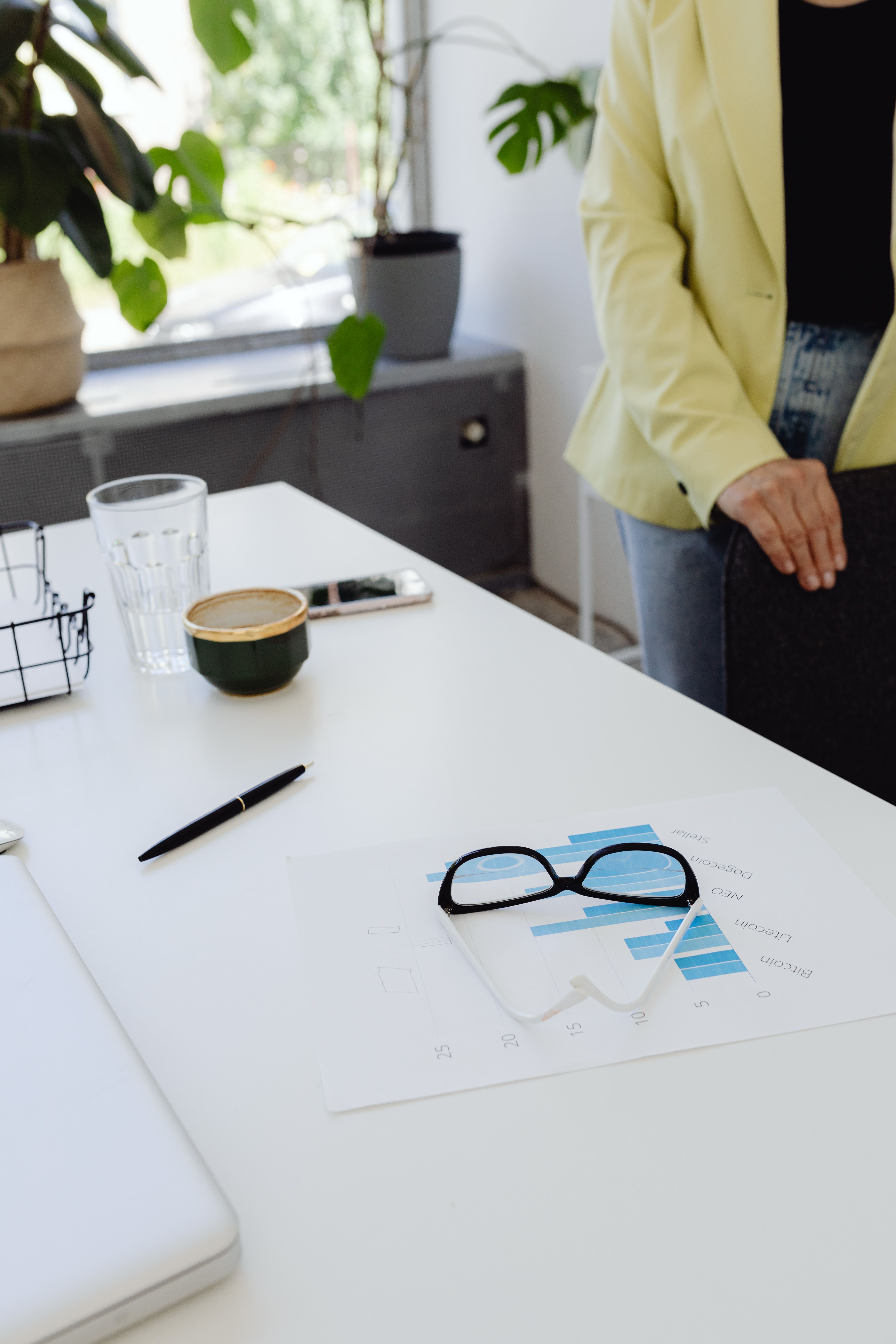 An ableist Karen coworker standing by a desk with papers and glasses, contemplating lecturing a coworker.