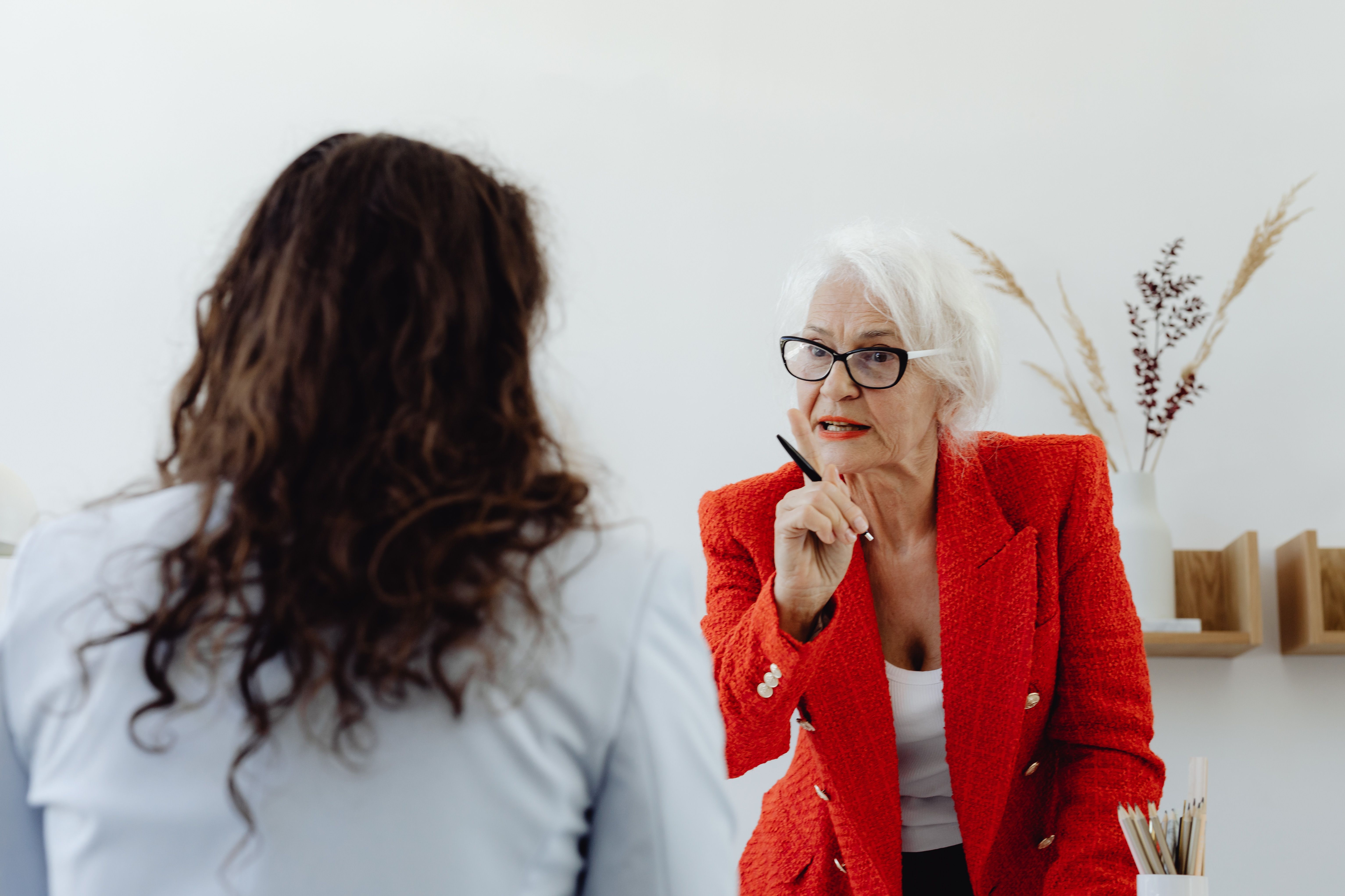 A senior woman, an Ableist Karen, lecturing her coworker for doing what is expected.