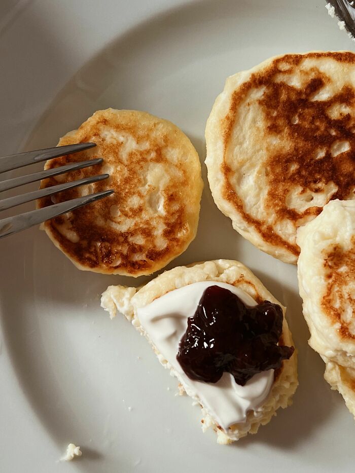 Plate of breakfast pancakes with jam and cream