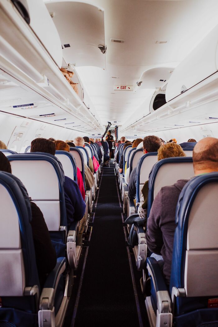 A wide shot of passengers on an airplane, illustrating a wild coincidence during travel.
