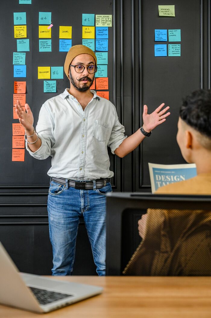 A secretly smart man presenting ideas, indicating his intelligence with clear hints and organized thoughts.
