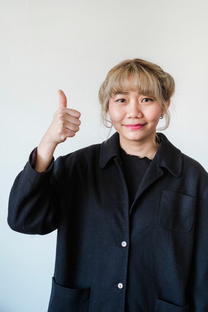 A woman giving a thumbs up, revealing hints that show a person is secretly very smart.