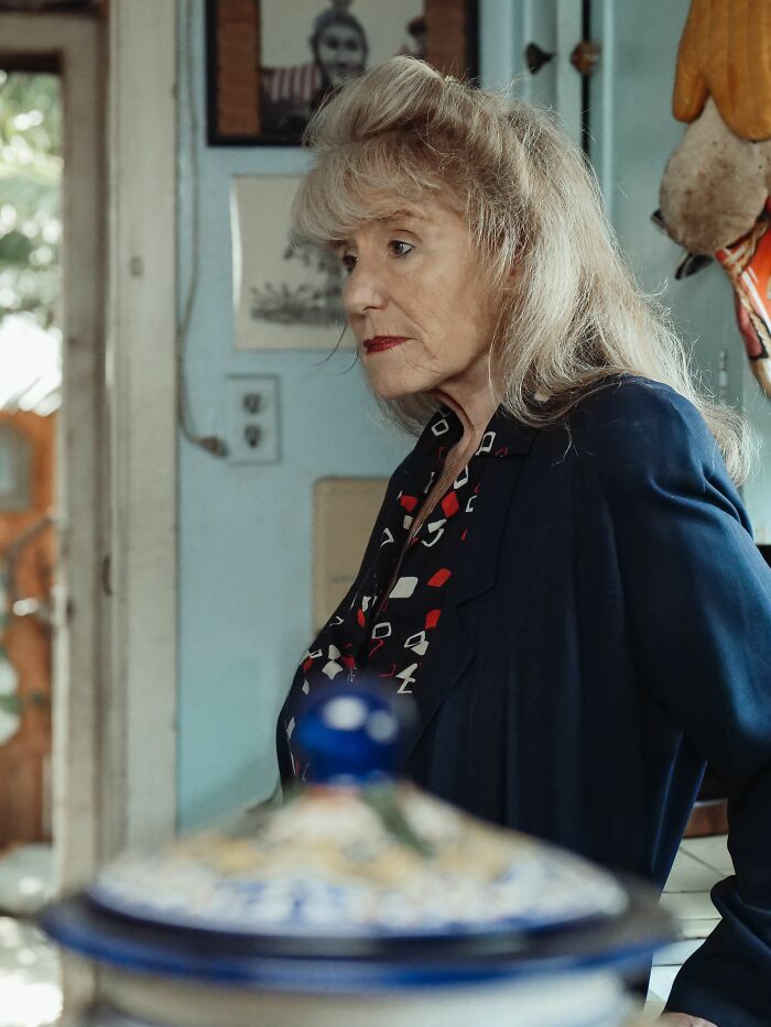 An older woman with blonde hair and red lipstick looks away, reflecting on people who hid their true selves.