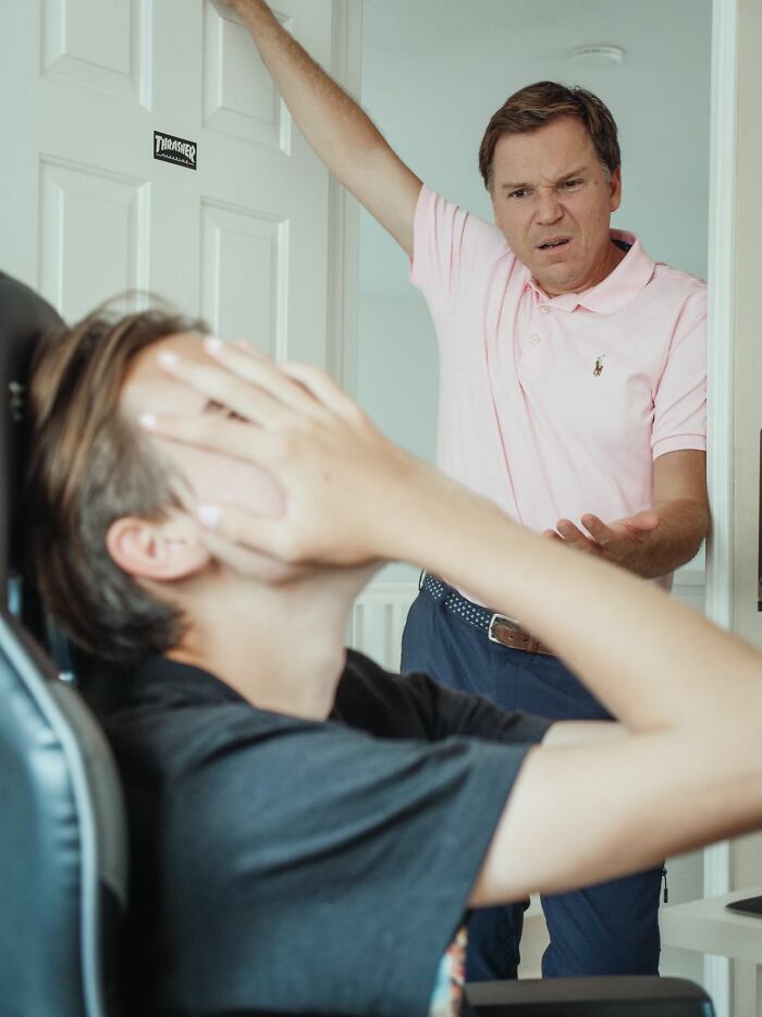 Frustrated parent confronting teenage child ignoring rules at home