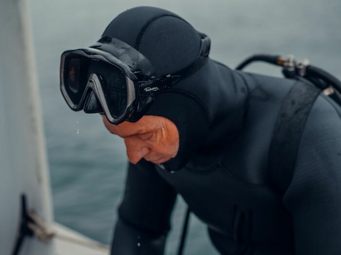 Diver in wetsuit and diving mask preparing for dive
