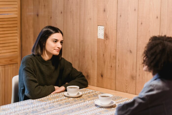 Two women having a serious conversation over coffee about a gender reveal event Two women having a serious conversation over coffee about a gender reveal event