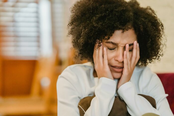 Woman distressed holding her face in hands Woman distressed holding her face in hands