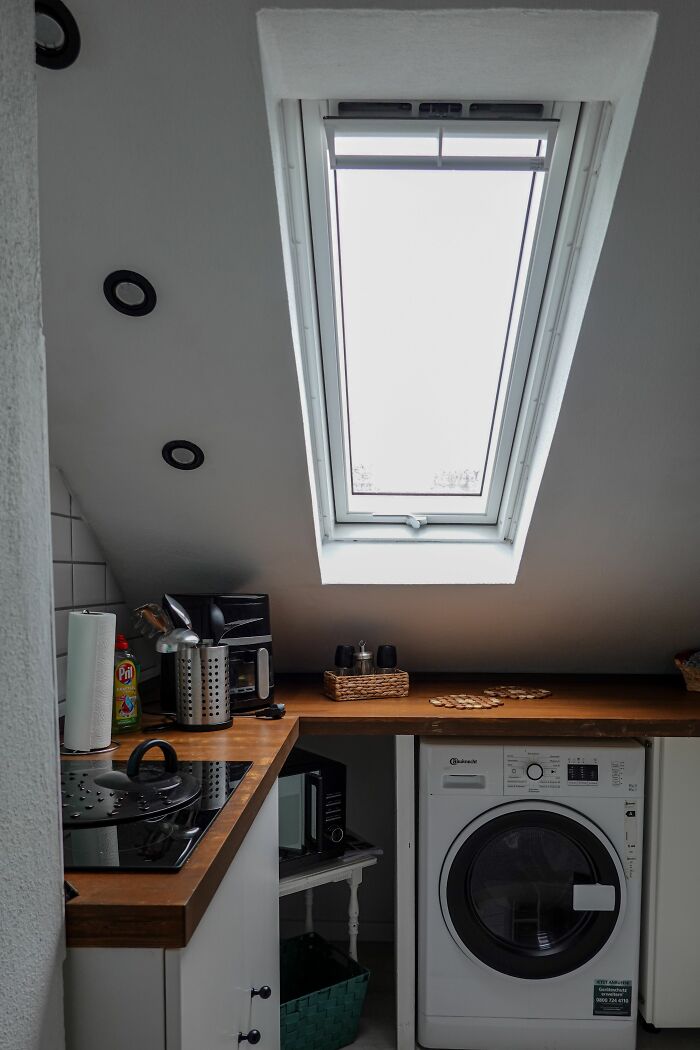 Cozy British kitchen with wooden countertops and a skylight window above appliances