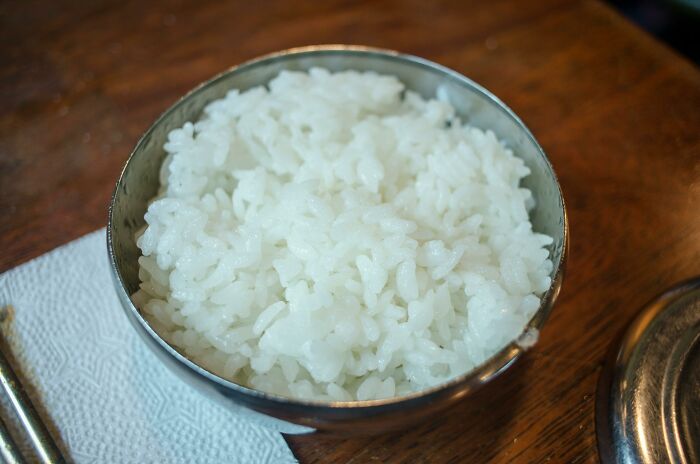 Steamed white rice served in metal bowl on table food facts