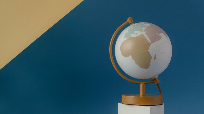 Modern globe featuring Africa and Europe against a two-tone blue and beige background Modern globe featuring Africa and Europe against a two-tone blue and beige background