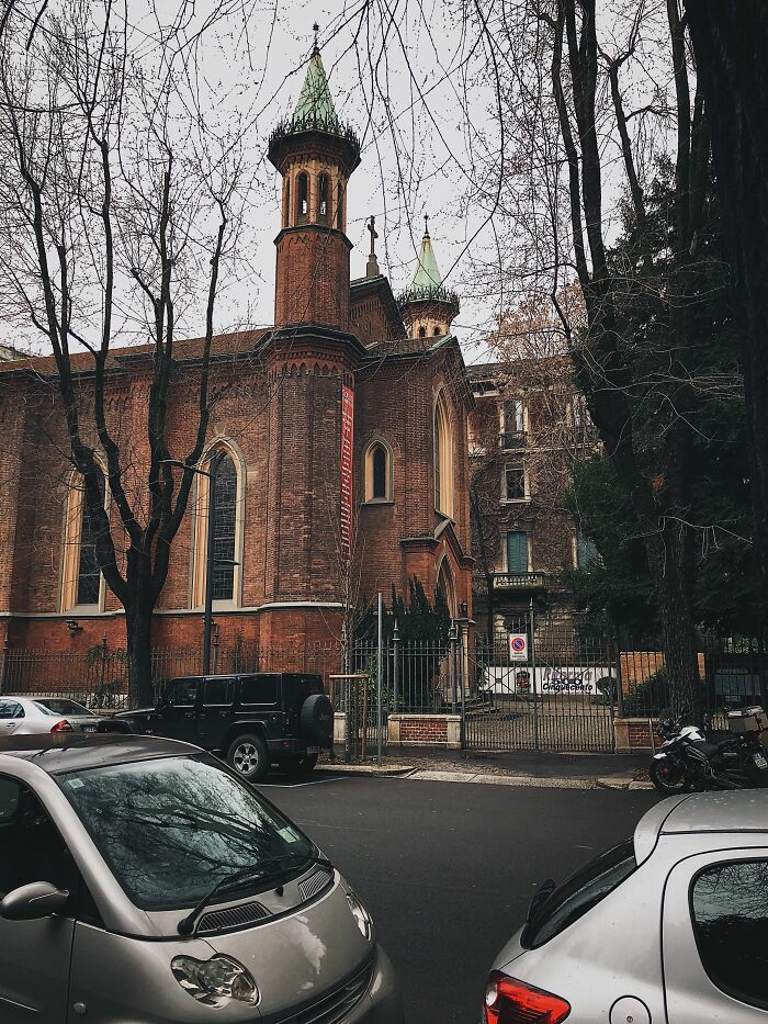 An old brick building with towers and bare trees, a setting where wild coincidences might occur.