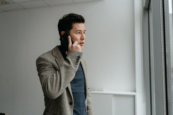 Man talking on phone looking serious about infidelity story