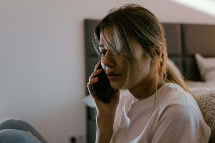Worried woman talking on phone in dimly lit room