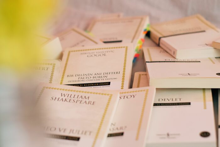 A pile of literature quiz books by classic authors like Shakespeare and Gogol, some with colorful bookmarks, ready for a quiz. A pile of literature quiz books by classic authors like Shakespeare and Gogol, some with colorful bookmarks, ready for a quiz.