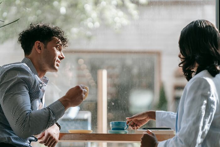Two people talking in a cafe, discussing mens turn-offs.