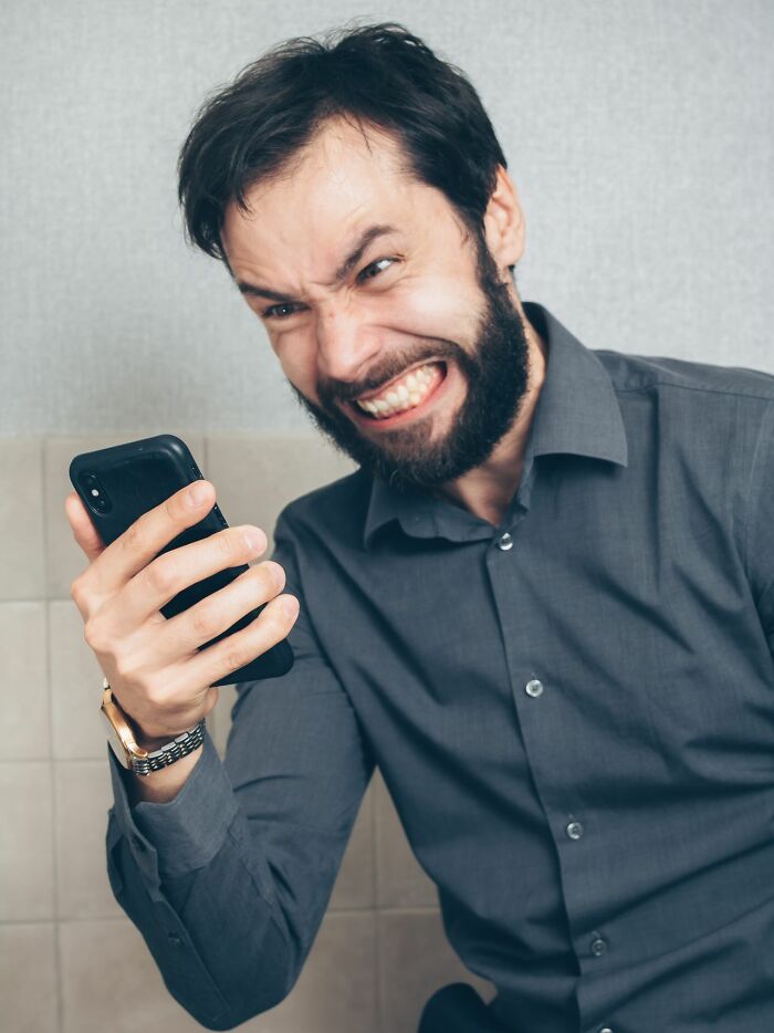 Angry man frustrated with phone showing entitled parent reaction