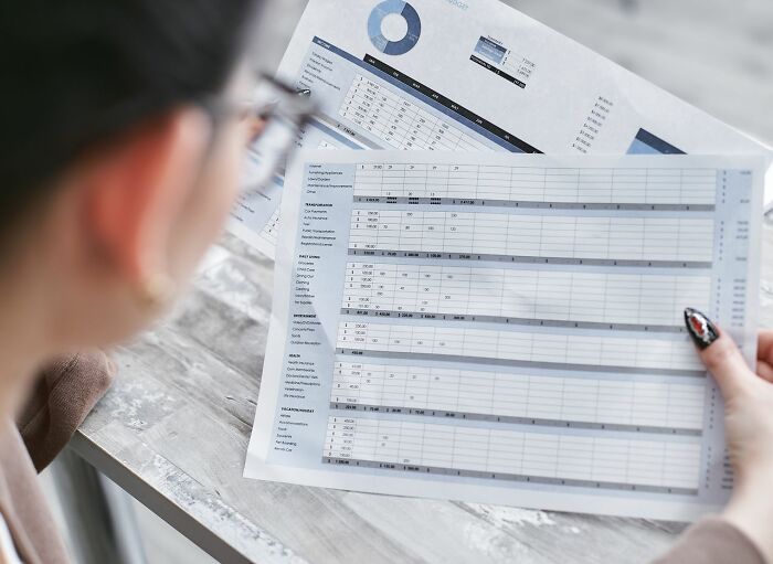 A person reviewing financial documents, possibly revealing partners phone secrets.