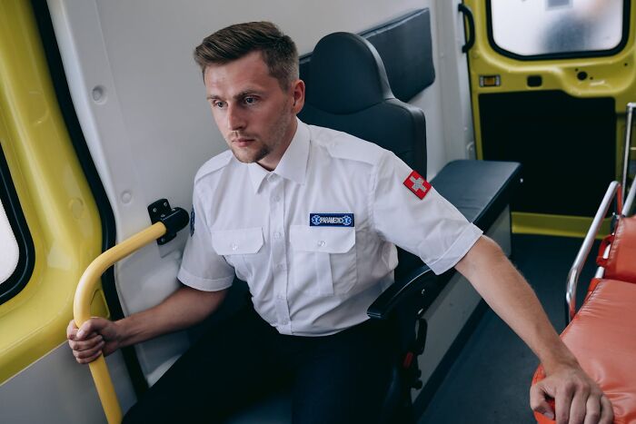 Paramedic sitting in ambulance interior during emergency response