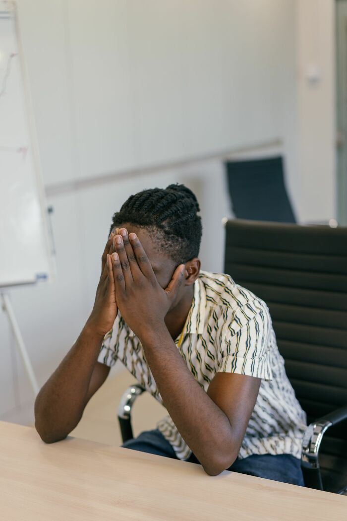 A man covering his face with his hands, depicting the emotional impact of courtroom stories.