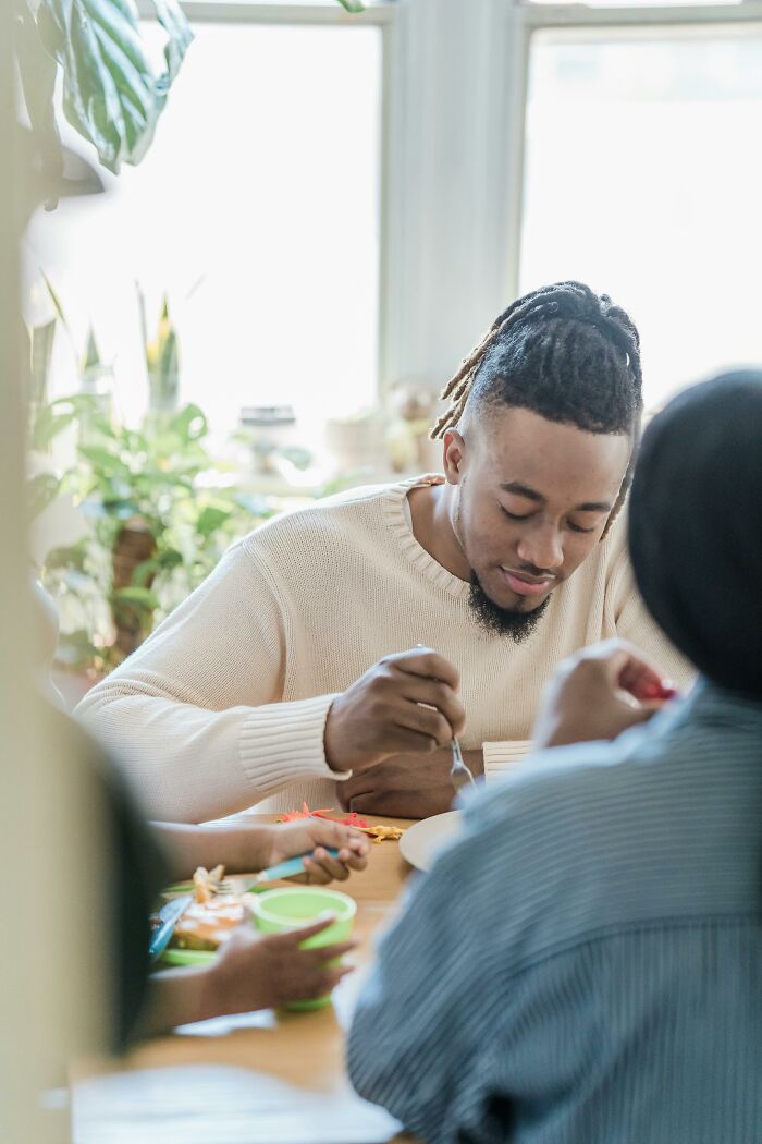 Young man enjoying a meal during a casual gathering indoors