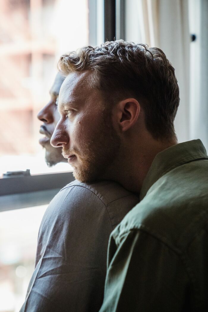 Two men looking out a window, contemplating worst things people found on their partners phone.
