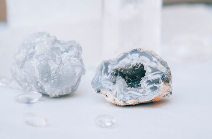 A pair of geodes, one open revealing crystals, on a white surface, representing wild coincidences.