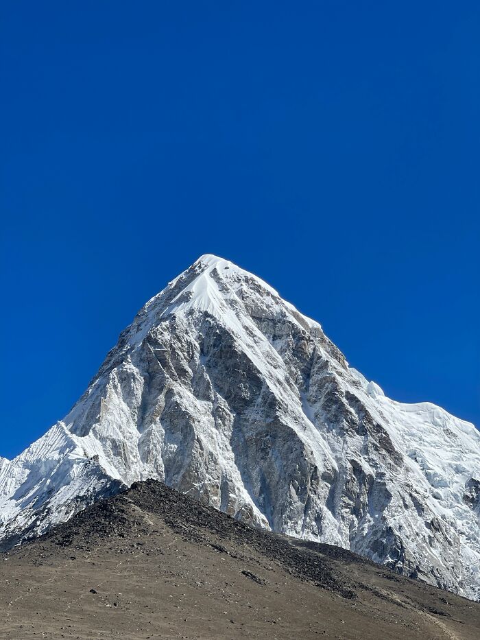 A majestic snow-capped mountain peak under a clear blue sky, presenting cool and interesting facts of nature.