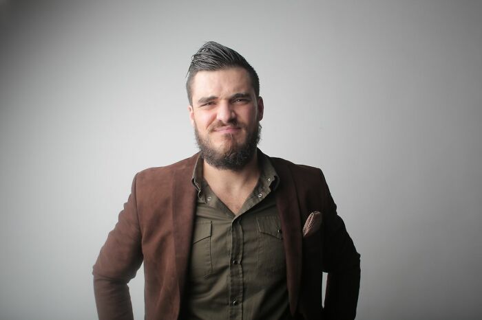 A man with a beard smiling, likely reacting to surprising courtroom stories.