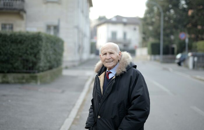 Elderly man wearing a winter coat standing on a street