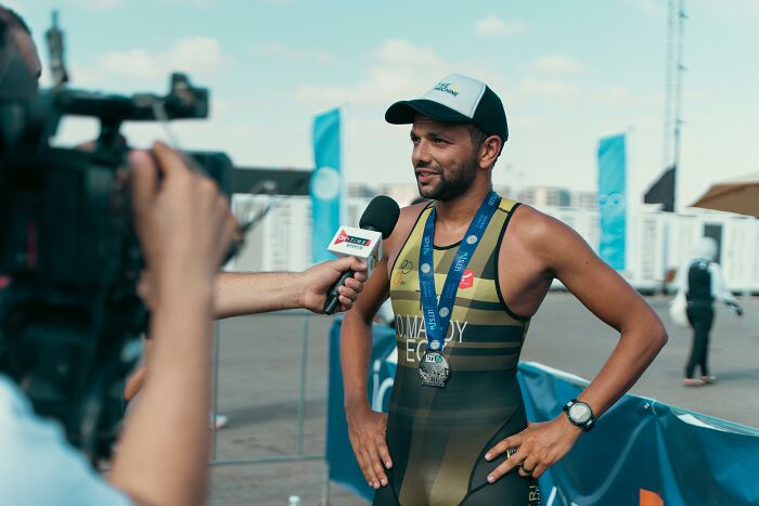 Athlete wearing medal being interviewed after race event