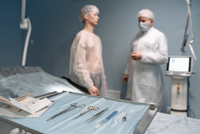 Medical instruments on a tray with a doctor and patient in the background, discussing human bodies and facts.