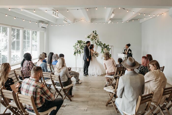 Indoor wedding ceremony with couple and seated guests