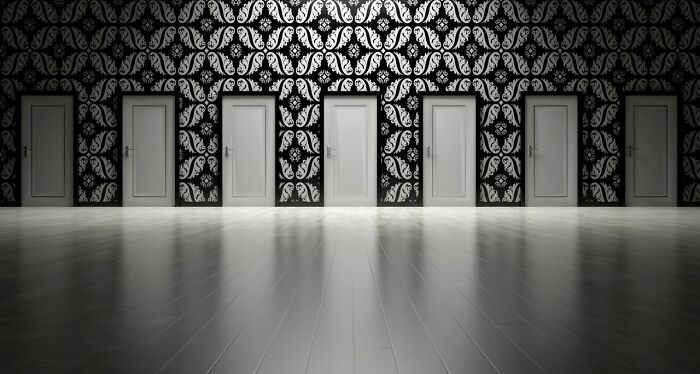 Row of closed doors with one door glowing bright