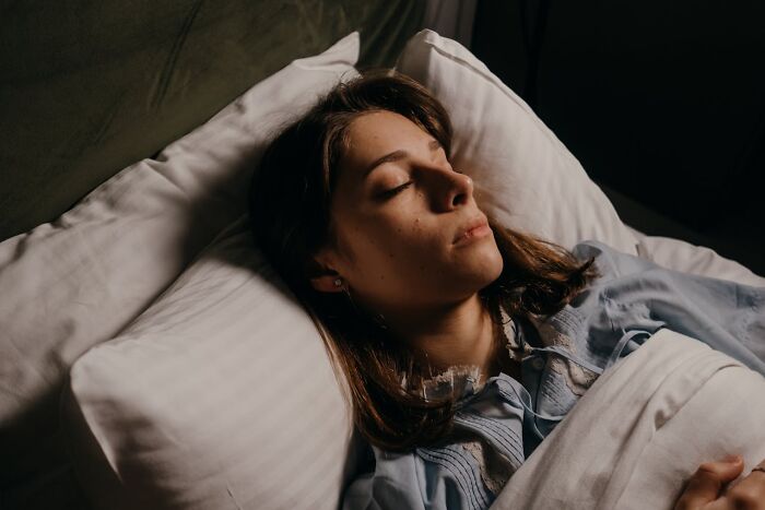Woman resting with eyes closed in bed illustrating shocking partner phone discoveries