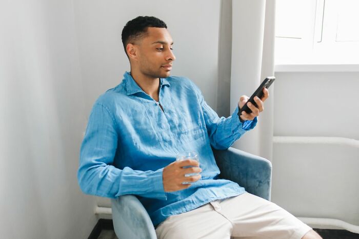 Man calmly checking phone messages involved in shocking partner phone discoveries